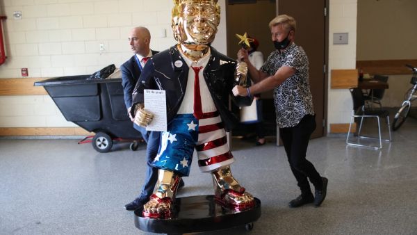 Matt Braynard (L) helps artist Tommy Zegan (R) wheel his statue of former President Donald Trump to a van during the Conservative Political Action Conference on February 27, 2021 in Orlando, Florida. Begun in 1974, CPAC brings together conservative organizations, activists, and world leaders to discuss issues important to them. Joe Raedle/Getty Images/AFP Trump all in gold! Anyway for the taking?