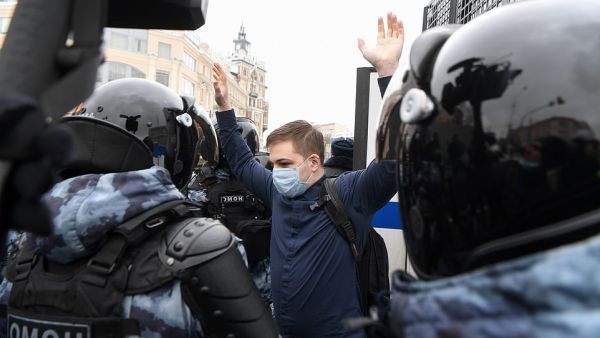 A protester holds up his arms while surrounded by riot police who detained him during the crackdown on anti-Putin rallies. (AFP/File)
