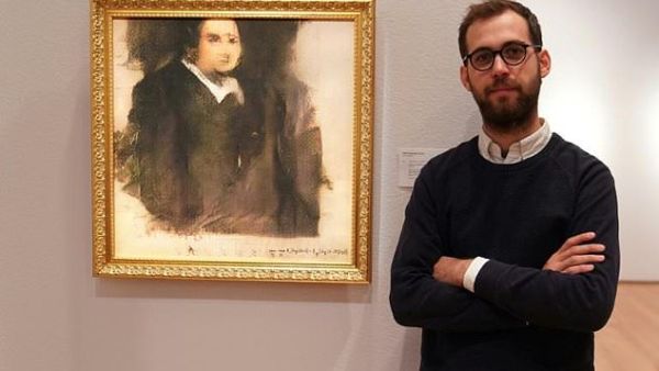 Pierre Fautrel, a member of the French art collective Obvious, poses in front of 'Portrait d'Edmond Belamy,' an image created using artificial intelligence that sold for a whopping £337,000 in 2018. (AFP)