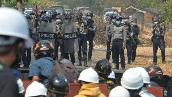 Riot police hold their firearms as they face off with protesters 