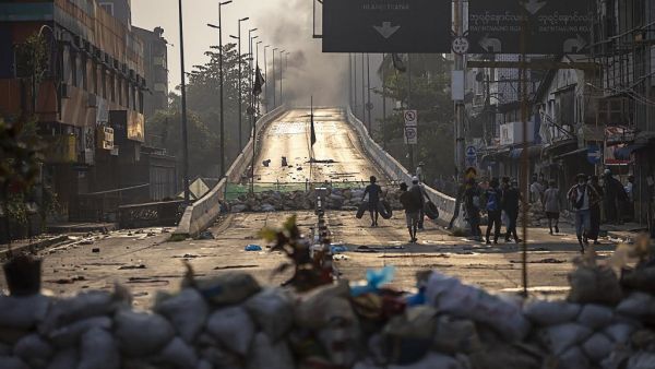 Protesters carry tires to construct makeshift barricades during demonstrations against the military coup in Yangon on March 15, 2021. STR / AFP Protesters carry tires to construct makeshift barricades