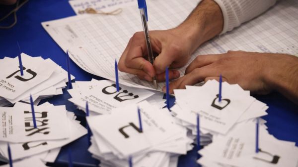 Electoral workers count ballots in Israel's general elections in Jerusalem on March 25, 2021. As the count continues in Israel's March 23 general elections, parties engage in intense horse-trading spelling more uncertainty ahead as the final results which are expected in the coming 24 hours. Emmanuel DUNAND / AFP Knesset general elections
