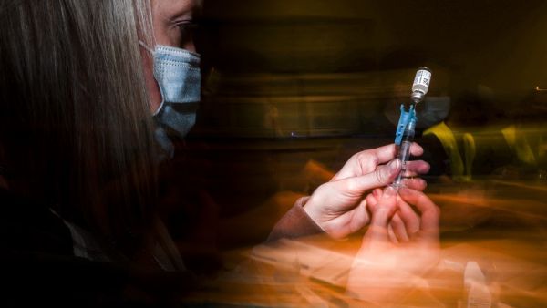  Adams 12 Five Star Schools District RN Tiffany Karschamroon draws a dose from a vial of the Johnson & Johnson COVID-19 vaccine