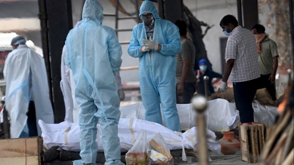 People wearing Personal Protective Equipment (PPE kit) perform the last rites to the body a person who died due to the Covid-19 coronavirus at a cremation ground in New Delhi on May 11, 2021. Money SHARMA / AFP bodies of Covid patients were found in river in India