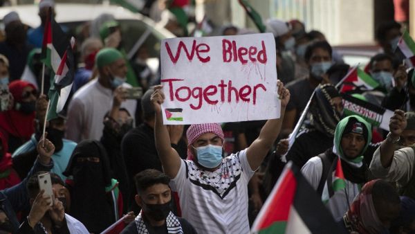 A demonstrator holds a placard in a  march through the city centre in Cape Town, on May 12, 2021 during a protest against Israeli attacks on Palestinians in Gaza as violence escalated between the bitter rivals sparked by unrest at Jerusalem's flashpoint Al-Aqsa Mosque compound