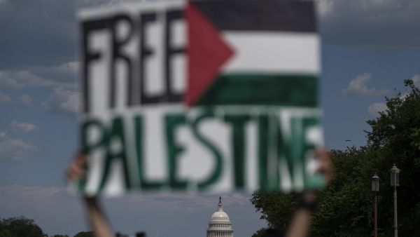 An activist holds up a sign with the US Capitol in the background, in support of Palestine, near the Washington monument in Washington, DC on May 15, 2021. US President Joe Biden, in a phone call with Israeli Prime Minister Benjamin Netanyahu, expressed his "grave concern" Saturday over the flareup of violence in Israel and Gaza, the White House announced