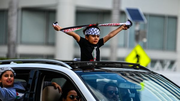 A young demonstrator holds a Palestine scarf during a rally in support of Palestine outside the US Federal Building & Courthouse in Fort Lauderdale