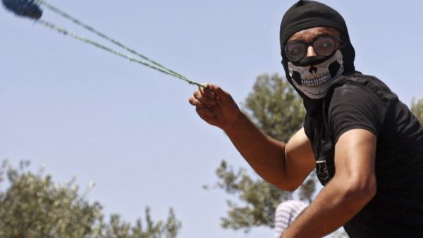A Palestinian protestor throws a rocks at Israeli security forces during clashes in the village of Beita, south of Nablus