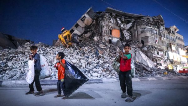 Palestinian boys walk past the destroyed Al-Shuruq tower in Gaza City's al-Rimal neighbourhood which was targeted by Israeli strikes during the recent confrontations between Hamas and Israel