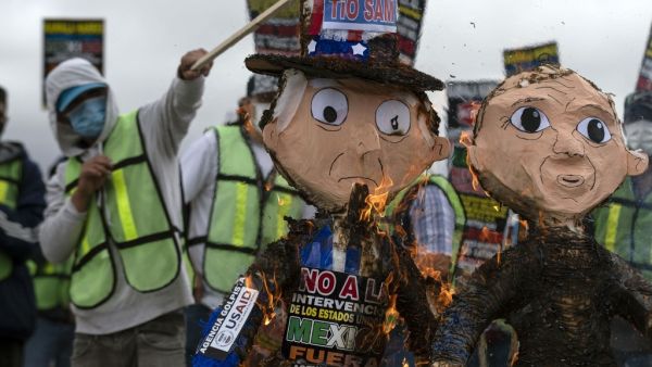 Migrants and pro-migrants advocates burn a pinata depicting Uncle Sam during a protest at the US Consulate in Tijuana, Baja California state, Mexico on June 7, 2021. Demonstrators asked US government to stop its 'intervention' in Mexico and a better treatment for migrants ahead of US Vice President Kamala Harris visit to Mexico City tomorrow. Guillermo Arias / AFP Trump administration separated 3,900 migrant children from families