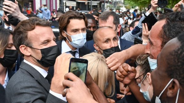 French President Emmanuel Macron interacts with members of a crowd while visiting Valence on June 8, 2021 during a visit in the French southeastern department of Drôme, the second stage of a nationwide tour ahead of next year's presidential election. PHILIPPE DESMAZES / POOL / AFP French President Macron slapped in face by member of public