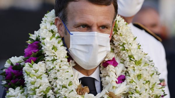 France's President Emmanuel Macron is covered in garlands during a welcoming ceremony upon his arrival at Faa'a international airport for a visit to Tahiti in French Polynesia on July 24, 2021. Ludovic MARIN / AFP Macron asks for explanation after Pegasus spyware incident