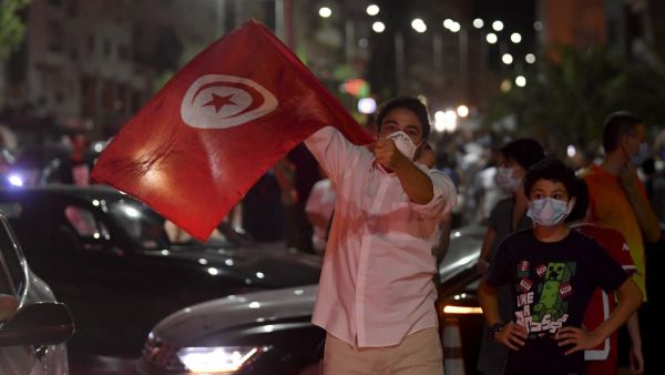 People celebrate in the street after Tunisian President Kais Saied announced the suspension of parliament and the dismissal of the prime minister in Tunis on July 25, 2021, after a day of nationwide protest. FETHI BELAID / AFP Former Tunisian President Moncef Marzouki also denounced Saied's move.