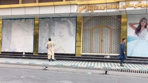 Taliban militants cover models' faces in Kabul streets