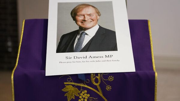 An image of murdered British Conservative lawmaker David Amess is displayed near the altar in St Peters Catholic Church before a vigil in Leigh-on-Sea, Essex, England, Friday, Oct. 15, 2021. (AP/Alberto Pezzali)