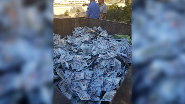 US dollars in trash bin