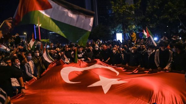 Protesters wave Turkish and Palestinian flags in front of the Israeli consulate in Istanbul