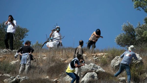 Masked Israeli settlers attack Palestinian olive farmers 