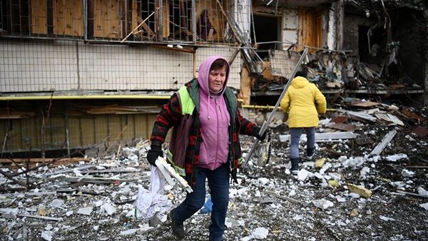 Woman clears items after a residential building in Kiev