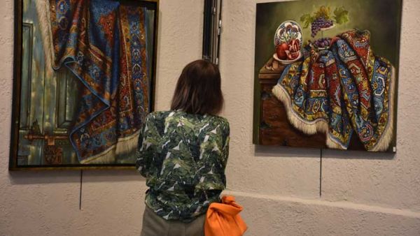 امرأة تركية تعكس نقوش السجاد على لوحات