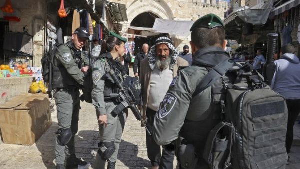 Israeli troops question an elderly Palestinian
