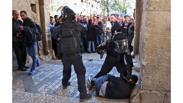 Israeli forces immobilize a Palestinian man at an entrance to the al-Aqsa