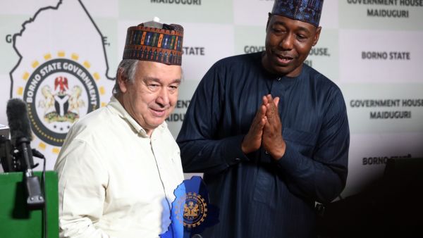 United Nations (UN) Secretary-General Antonio Guterres (L) reacts after receiving a plaque from the Borno State Governor, Babagana Zulum (R) during Guterres' first mission to Nigeria at the Maiduguri International Airport, Borno State, Nigeria on May 3, 2022. (Photo by Kola Sulaimon / AFP) United Nations Secretary-General Antonio Guterres