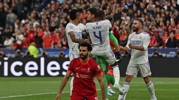 Real Madrid's teammates congratulate Real Madrid's Belgian goalkeeper Thibaut Courtois (rear C) after he saved a shot by Liverpool's Egyptian midfielder Mohamed Salah reacting on the foreground during the UEFA Champions League final football match between Liverpool and Real Madrid at the Stade de France in Saint-Denis, north of Paris, on May 28, 2022. (Photo by Paul ELLIS / AFP)