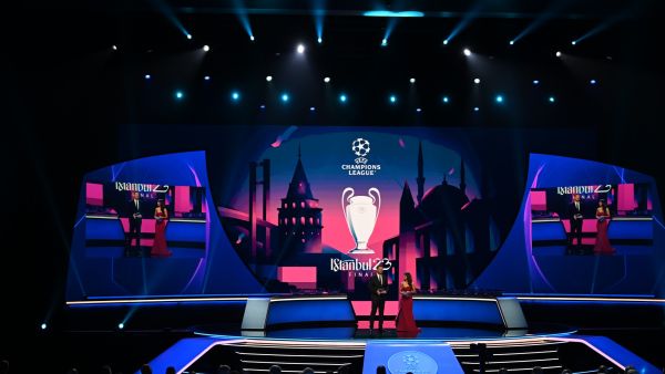 UEFA Managing Director of Communications Pedro Pinto (L) looks on next to British journalist Reshmin Chowdhury on stage during the draw ceremony for the 2022-2023 UEFA Champions League football tournament in Istanbul on August 25, 2022. (Photo by OZAN KOSE / AFP)