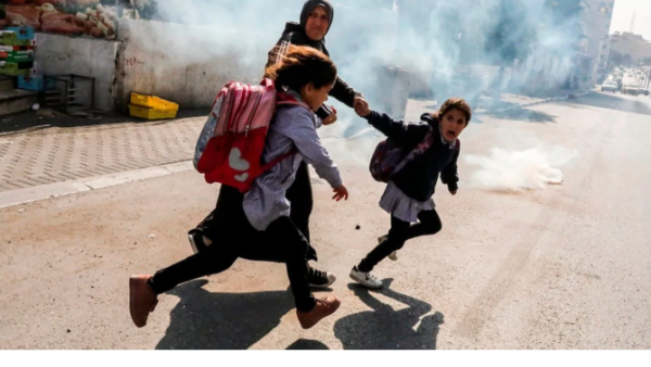 Palestinian mon and her kids run away from the gas canisters 