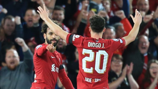 Liverpool's Egyptian striker Mohamed Salah (L) celebrates scoring his team's first goal with Liverpool's Portuguese striker Diogo Jota (back) during the UEFA Champions League group A football match between Liverpool and Ajax at Anfield in Liverpool, north west England on September 13, 2022. (Photo by Lindsey Parnaby / AFP)