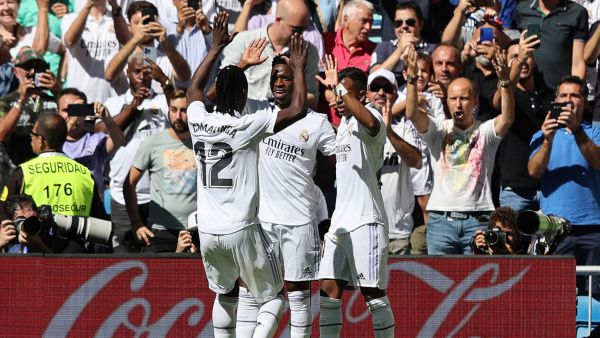 Real Madrid's Brazilian forward Vinicius Junior (C) celebrates with Real Madrid's French midfielder Eduardo Camavinga (L) and Real Madrid's Brazilian forward Rodrygo (R) after scoring his team's first goal during the Spanish league football match between Real Madrid CF and Real Betis at the Santiago Bernabeu stadium in Madrid on September 3, 2022. (Photo by Thomas COEX / AFP)