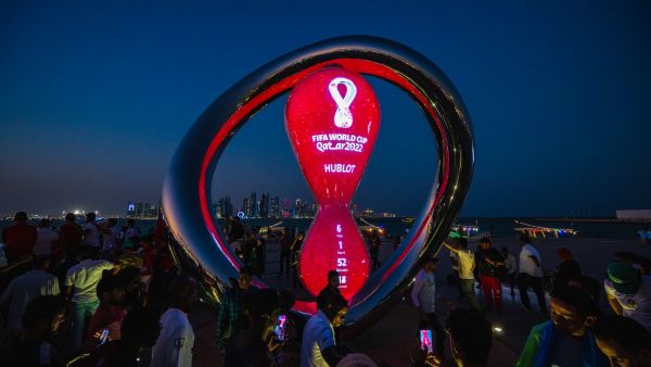 People gather for photos around the World Cup countdown clock in Doha on November 14, 2022, ahead of the Qatar 2022 World Cup football tournament. (Photo by ANDREJ ISAKOVIC / AFP)