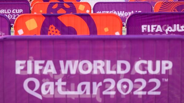A worker walks past FIFA World Cup banners outside the Khalifa Stadium in Doha on November 6, 2022, ahead of the Qatar 2022 FIFA World Cup football tournament. (Photo by Kirill KUDRYAVTSEV / AFP)