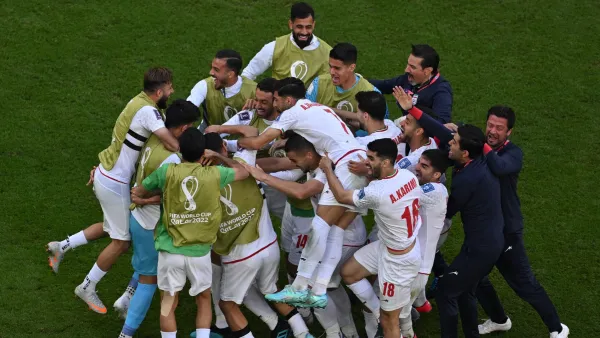 Iran's players celebrate after scoring the opening goal during the Qatar 2022 World Cup Group B football match between Wales and Iran at the Ahmad Bin Ali Stadium in Al-Rayyan, west of Doha on November 25, 2022. (Photo by Antonin THUILLIER / AFP)