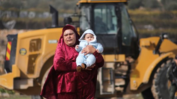 فلسطينية تحمل كفلا بعد ان هدمت قوات الاحتلال منزلها