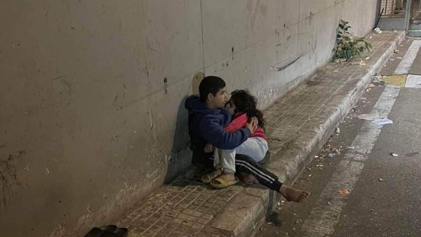 فتى لبناني يحتضن أخته الصغيرة بعد ليلة شديدة البرودة في شارع بالعاصمة بيروت.
