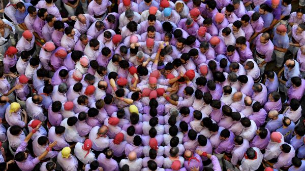 members of the "Jove de Tarragona" team attempt to form a "castell" (human tower) during the 28th edition of the 'castells' competition at the Tarraco arena in Tarragona on October 2, 2022. These human towers, built traditionally in festivals within Catalonia, gather several teams that attempt to build and dismantle a human tower structure. (Photo by Josep LAGO / AFP) Jove de Tarragona