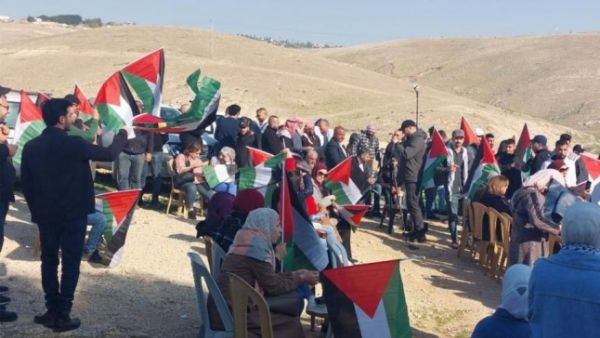 حشود من الفلسطينيين يرفعون الأعلام في "الخان الأحمر" شرق القدس المحتلة