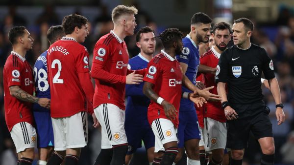English referee Stuart Attwell (R) explains his penalty decision to players during the English Premier League football match between Chelsea and Manchester United at Stamford Bridge in London on October 22, 2022. (Photo by ADRIAN DENNIS / AFP) 