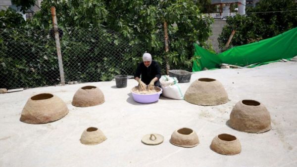 فلسطينية تصنع الطابون التقليدي من صلصال وتبن