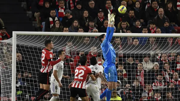 Real Madrid's Belgian goalkeeper Thibaut Courtois (R) jumps for the ball during the Spanish league football match between Athletic Club Bilbao and Real Madrid CF at the San Mames stadium in Bilbao, on January 22, 2023. (Photo by ANDER GILLENEA / AFP)