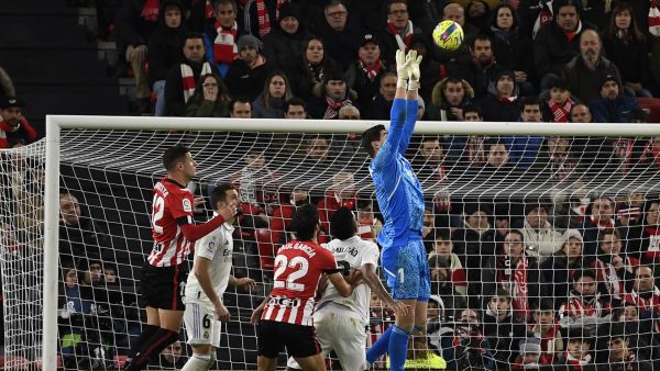 Real Madrid's Belgian goalkeeper Thibaut Courtois (R) jumps for the ball during the Spanish league football match between Athletic Club Bilbao and Real Madrid CF at the San Mames stadium in Bilbao, on January 22, 2023. (Photo by ANDER GILLENEA / AFP)