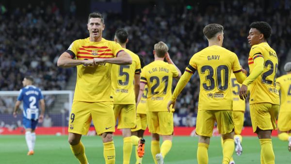 Barcelona's Polish forward Robert Lewandowski (L) celebrates scoring the opening goal during the Spanish league football match between RCD Espanyol and FC Barcelona at the RCDE Stadium in Cornella de Llobregat on May 14, 2023. (Photo by Lluis GENE / AFP)
