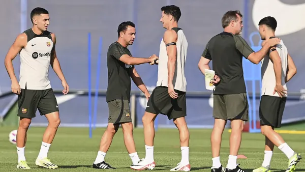 Barcelona's Spanish coach Xavi (2L) shakes hands with Barcelona's Polish forward #9 Robert Lewandowski (C) next to Barcelona's Spanish forward #07 Ferran Torres (L) during a training session at the Joan Gamper training ground in Sant Joan Despi, near Barcelona, on August 12, 2023, on the eve of their first Spanish Liga football match of this season, against Getafe CF. (Photo by Pau BARRENA / AFP)