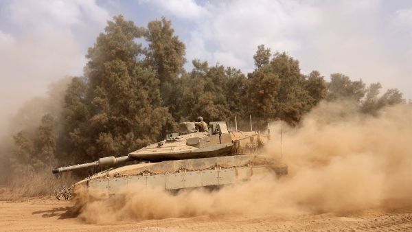 An Israeli army Merkava battle tank deploys with others along the border with the Gaza Strip in southern Israel on October 13, 2023. (MENAHEM KAHANA/AFP) Israeli army