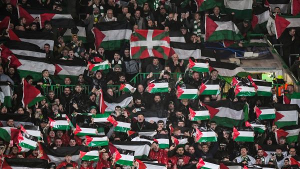 جماهير سيلتك ترفع أعلام فلسطين خلال المباراة أمام أتلتيكو مدريد (Photo by ANDY BUCHANAN / AFP)