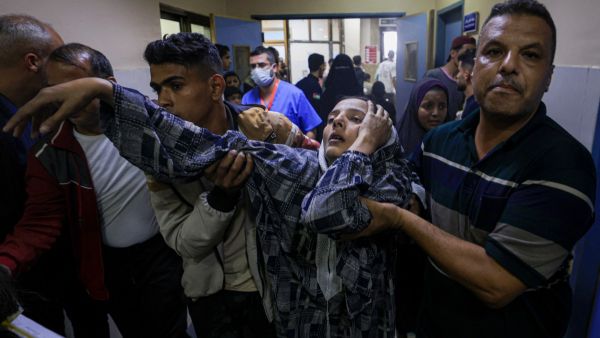A wounded Palestinian woman trying to reach the emergency ward in south Gaza on November 13, 2023. (Mahmud Hams/ AFP)