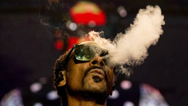 Snoop Dogg blows smoke as he performs on stage at the Accor Arena of Bercy, in Paris. (Anna Kurth/ AFP)