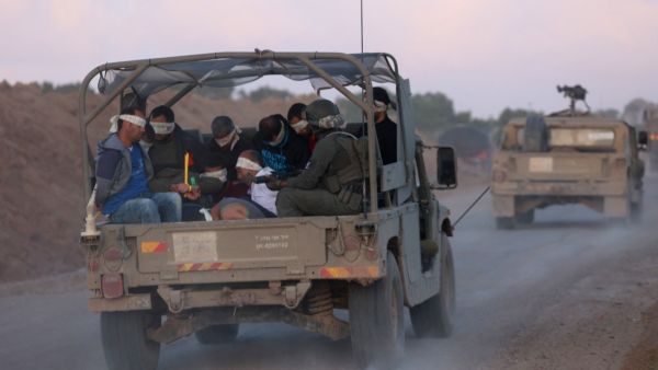 Israeli soldiers transfer detained Palestinians out of the Gaza Strip on November 20, 2023. (Gil Cohen Magen/ AFP)